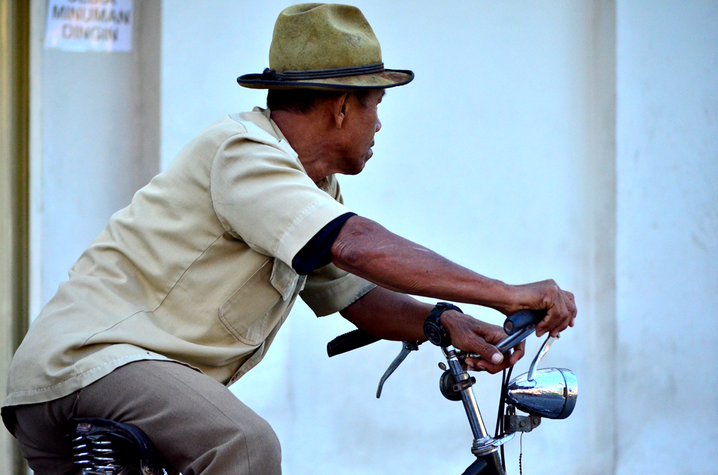 a man with a hat riding a bike