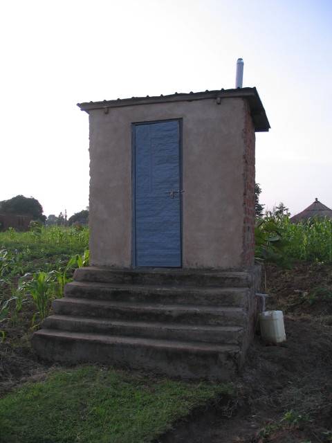 a small house made out of concrete with blue doors and steps