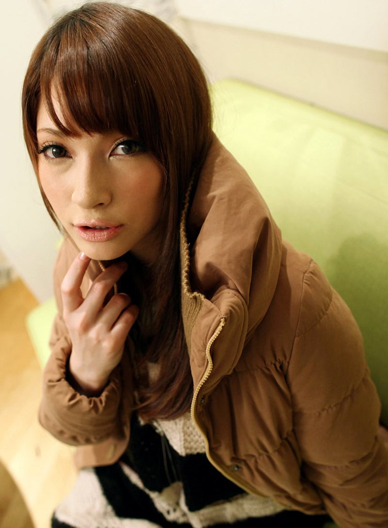 young woman in brown jacket posing for the camera
