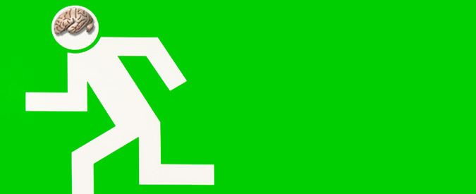 a white pedestrian walk sign on a green background