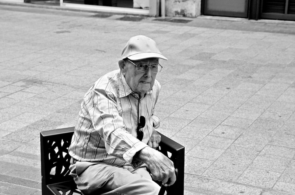 a man in hat sitting on a bench