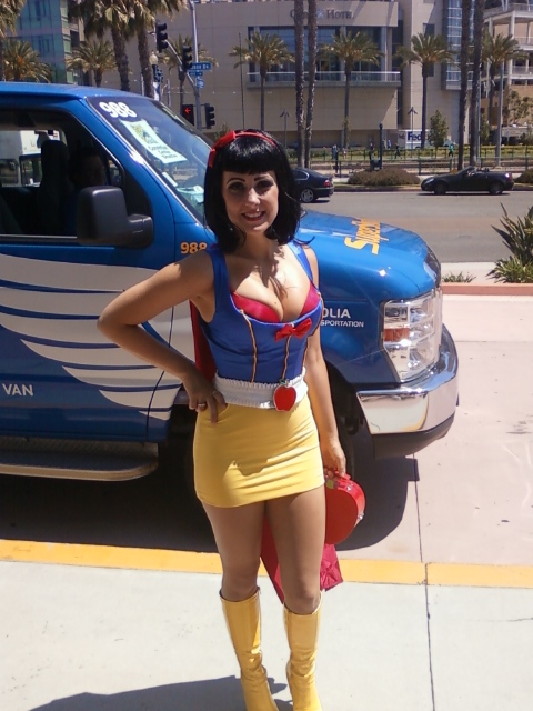 a woman standing next to a bus in a yellow skirt