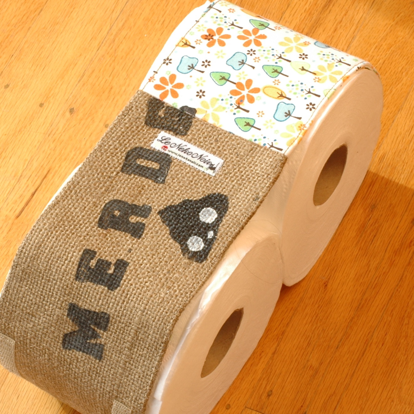 a couple of rolls of toilet paper on top of a wooden floor