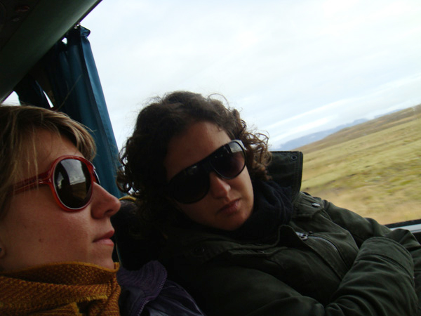 two people ride on a bus through the countryside