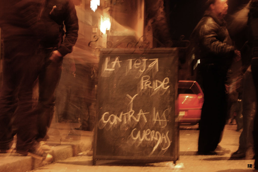 two men standing in front of a sign with writing on it