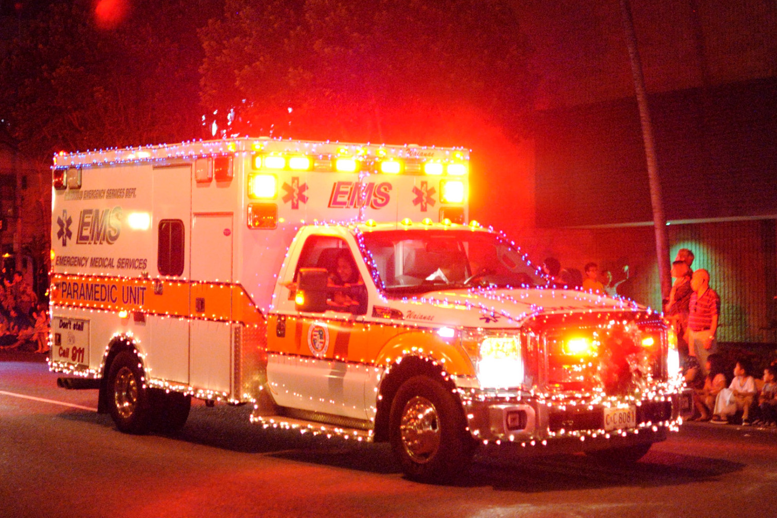 an ambulance drives down the road decorated with christmas lights