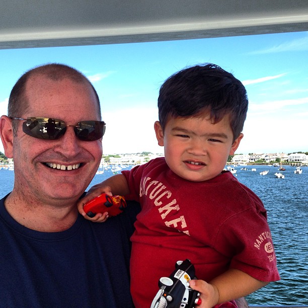 a man holding a boy on top of a boat