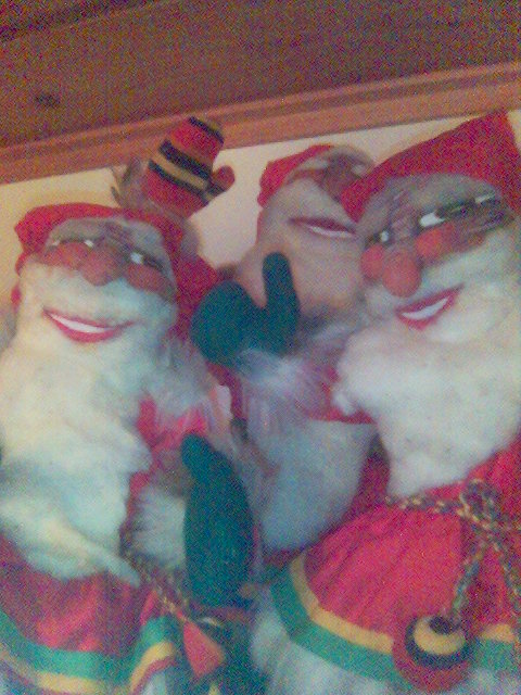 three christmas characters with santa claus holding the head