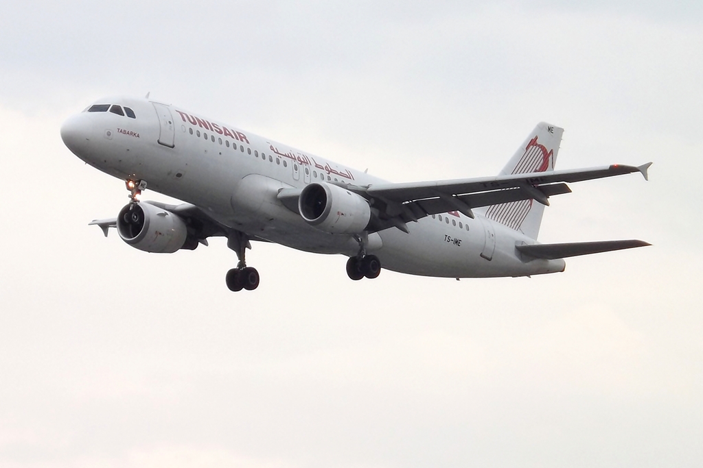 an airplane flying in the air on a cloudy day