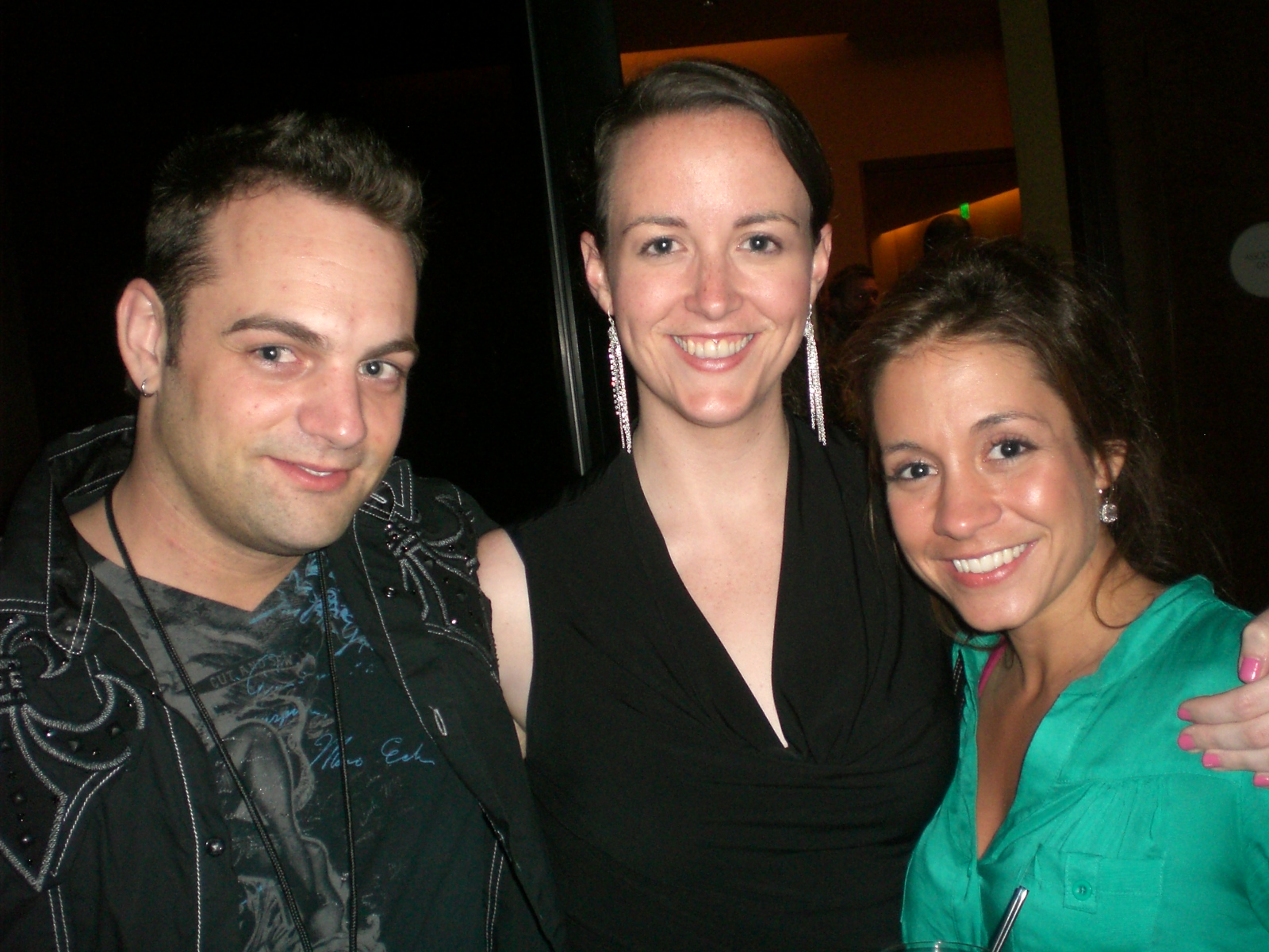 two women and a man posing for the camera