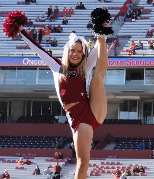 a cheerleader is doing a stunt on the sideline