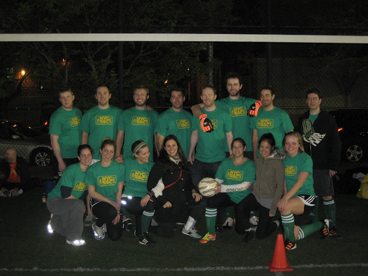 soccer players in green shirts posing with a ball