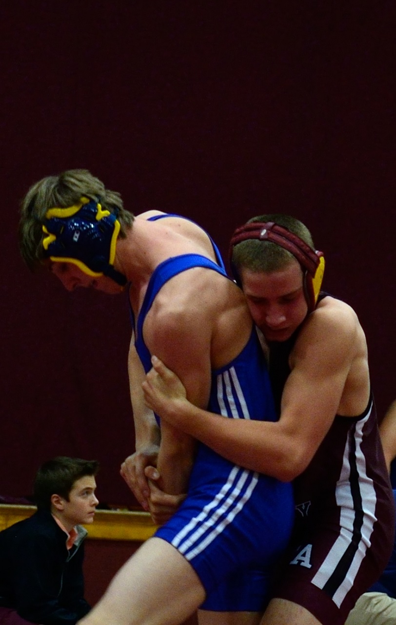 two wrestling players face each other in an indoor arena