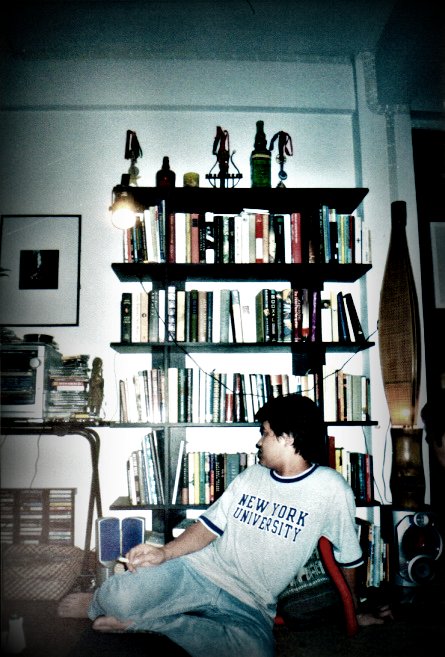 boy playing a game at home in front of his bookshelf