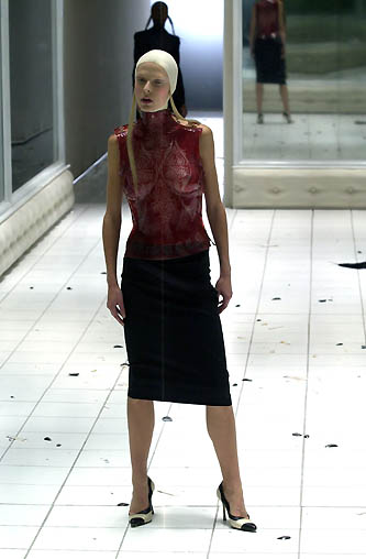 a woman walks on a tiled walkway wearing a skirt
