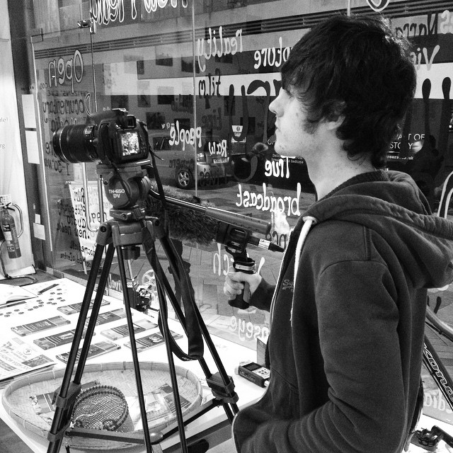 a man is standing by a tripod looking at soing