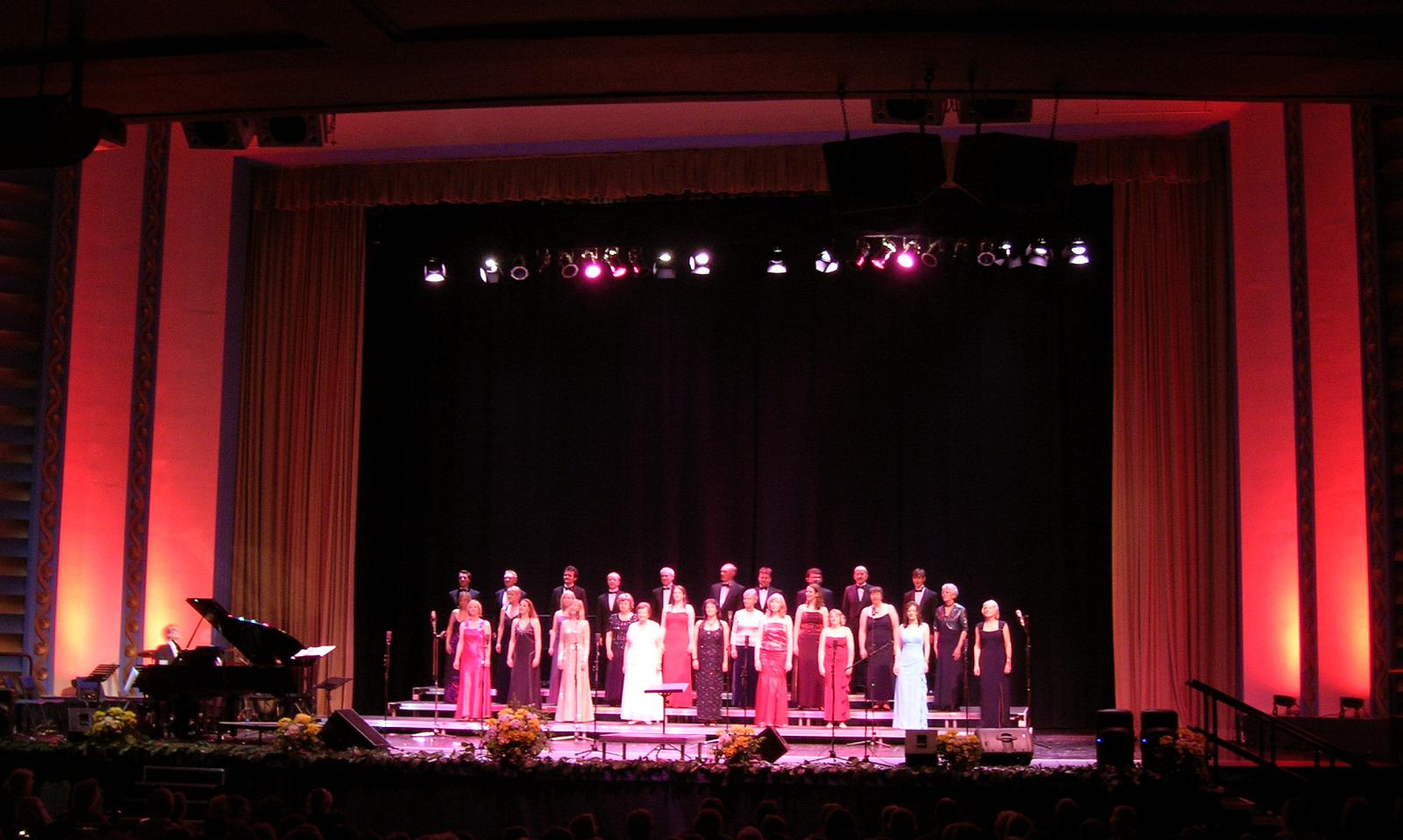 a concert scene with an audience in red dress