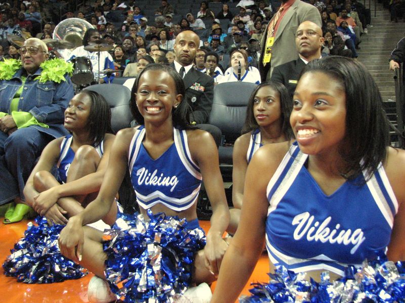 four cheerleaders in a crowd during a game