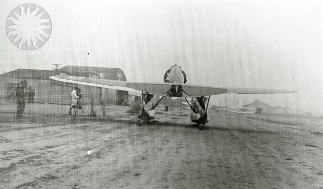 an old airplane with some people standing in front of it