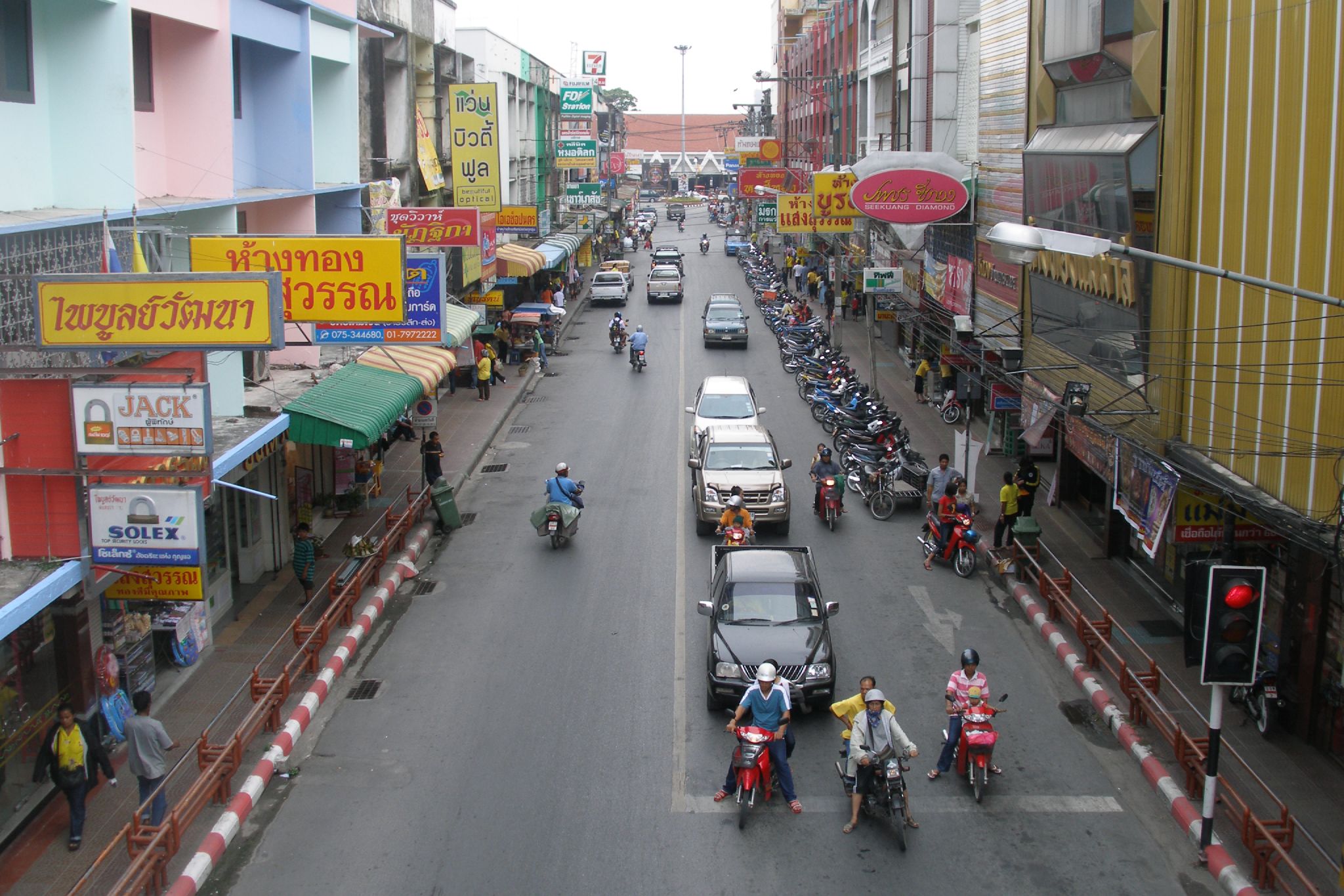 an aerial view of a city street with a small crowd on a motor cycle