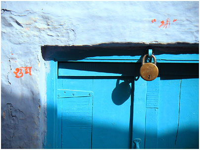 a blue door with a rusted metal padlock