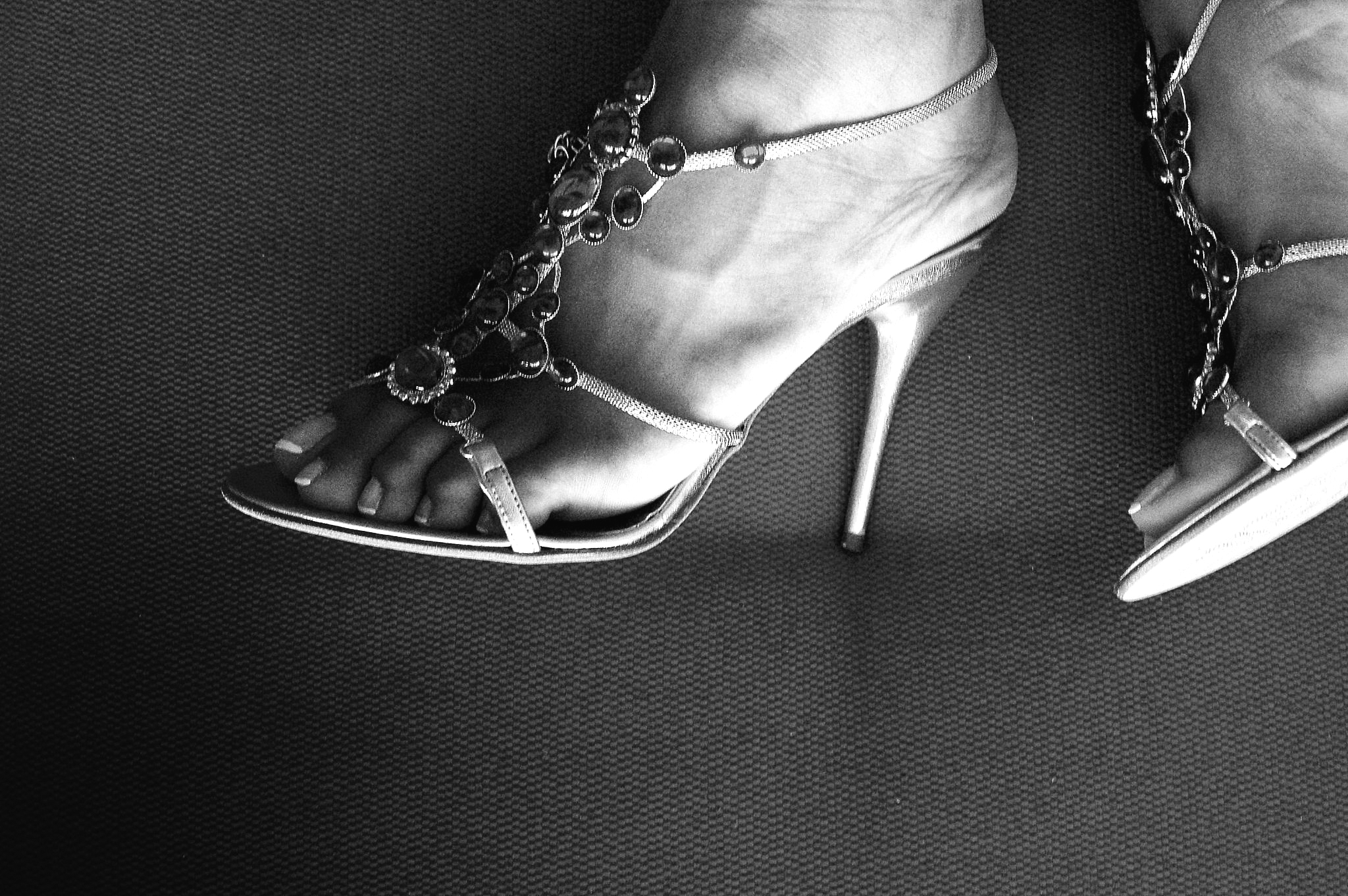 a woman in heels and chain - detailed sandals
