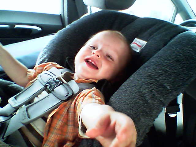 a child in a car seat with a baby