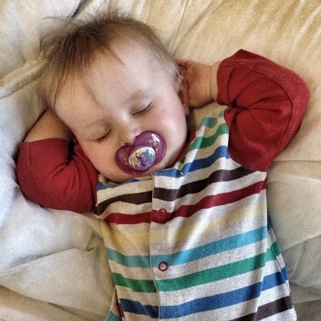 a child is sleeping with a pacifier in its mouth