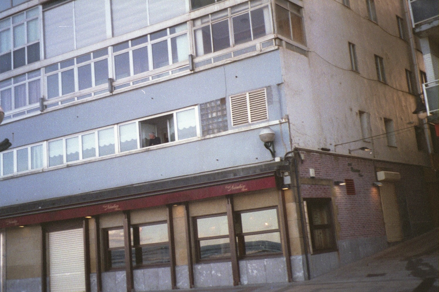 a building with a few windows next to a street light