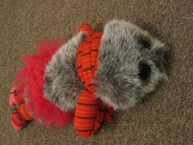 the grey, orange, and red toy is on the carpet