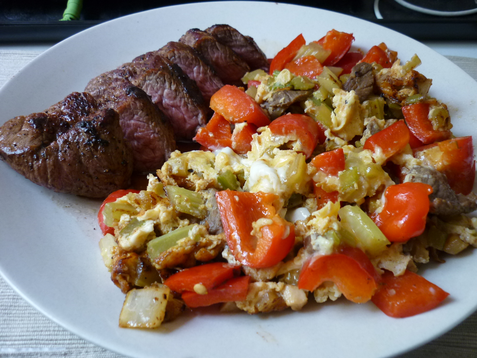 steak and vegetables are on a plate next to bread