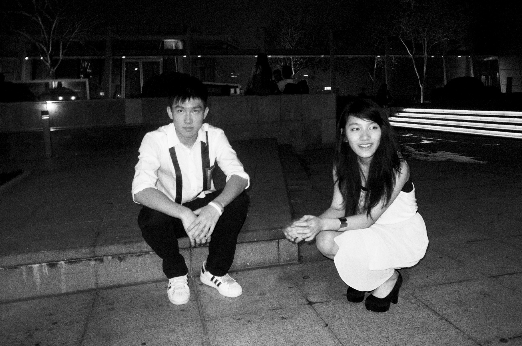 a young woman and boy sit on the stairs while they pose for a black and white po
