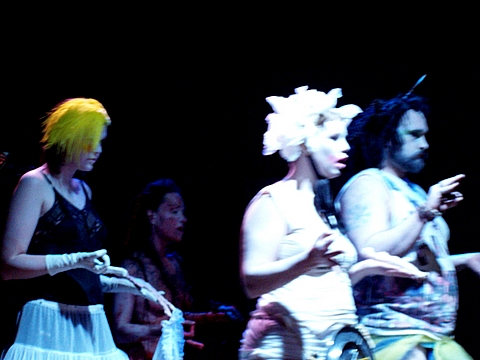 group of woman wearing headdress while standing on stage