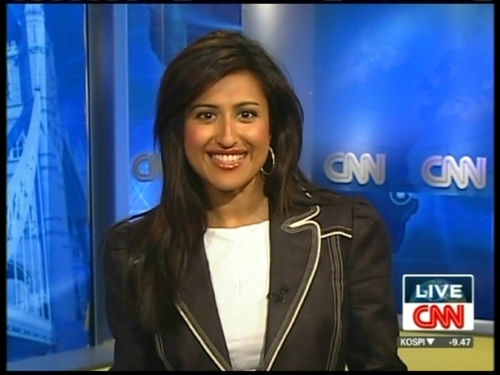 a woman smiles as she sits down on the news