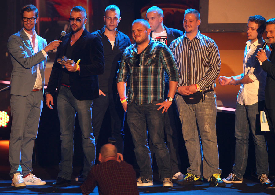 five men pose for the camera on stage at an event