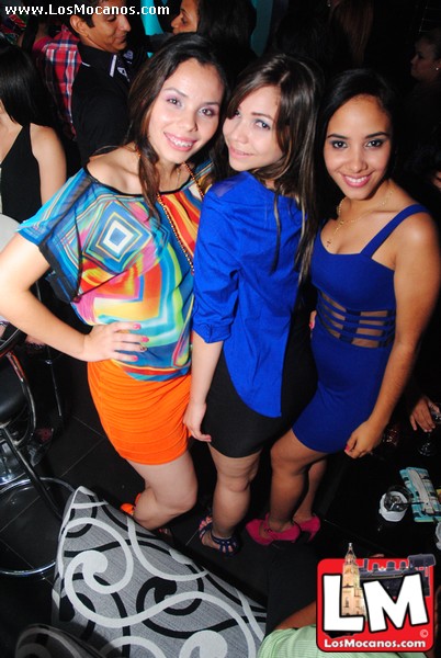 some beautiful young ladies standing together in front of a dj booth