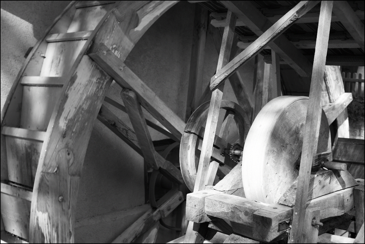 a wooden wheel with metal wheels inside of a room