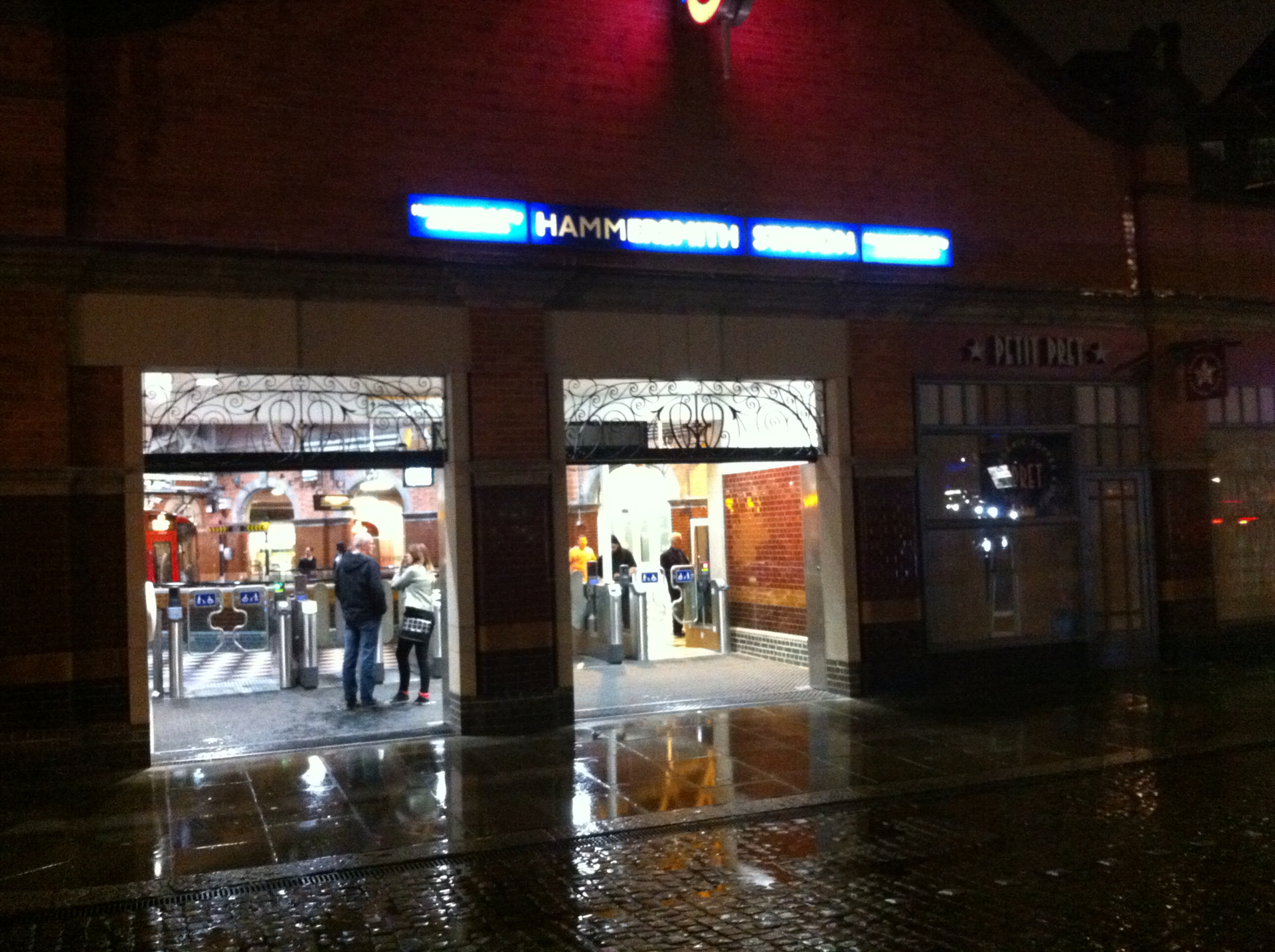 people walking inside of an entrance in a dark building