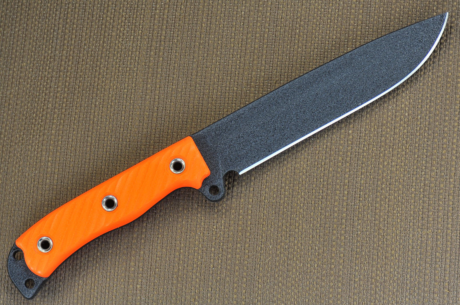 a knife with an orange blade on a brown background