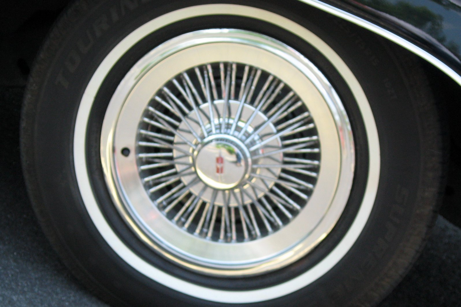 wheel spokes on a vintage black car with gold rim