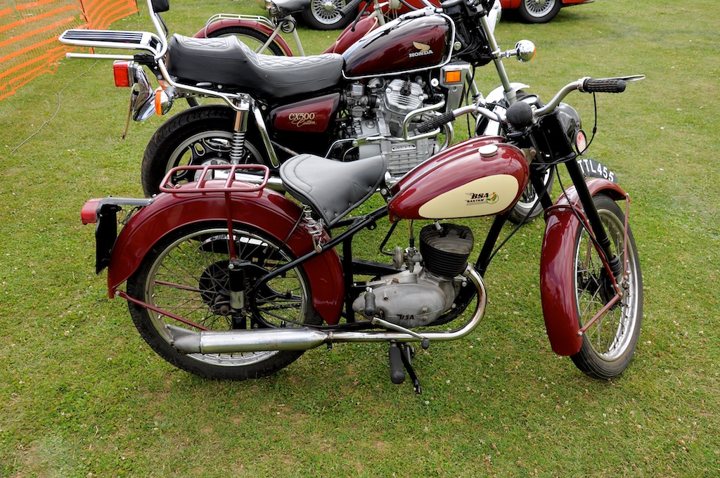a row of motorcycles is shown parked in the grass