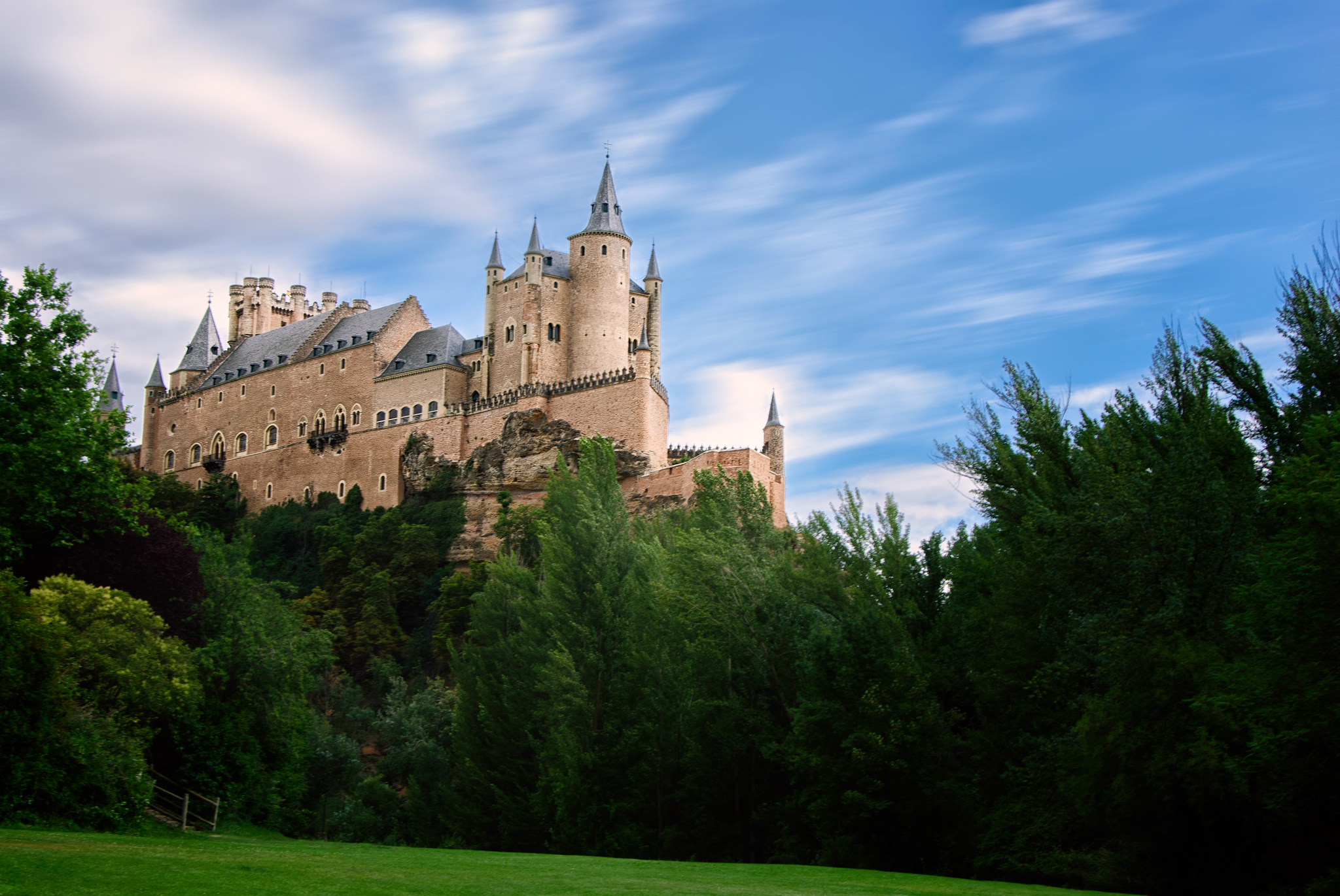 a castle sitting on top of a mountain surrounded by trees