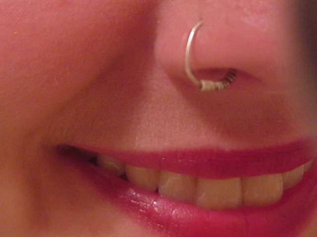 woman's smile has piercings on it