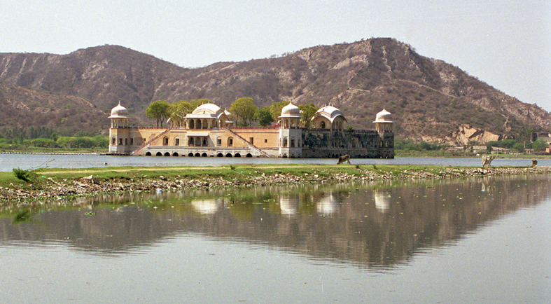 a palace like building sits next to a body of water