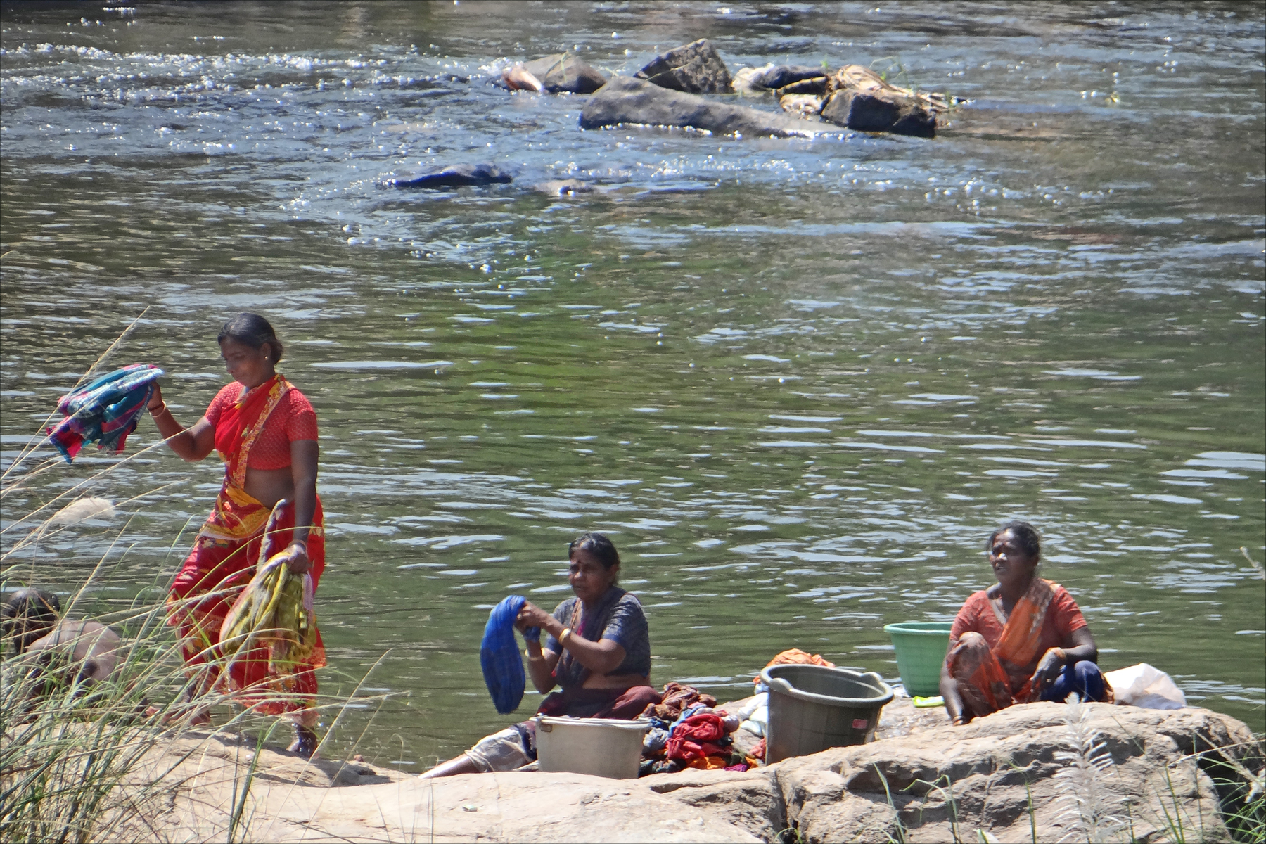 people in the water are getting their belongings out of a container