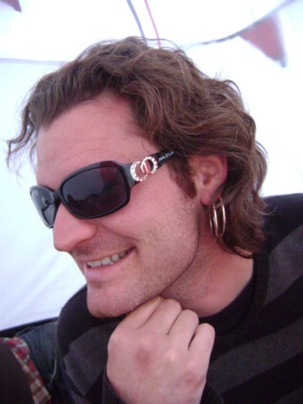a young man wearing sunglasses poses for the camera