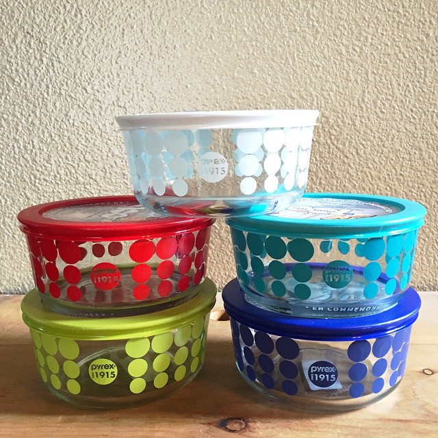 four colored plastic containers of food with dots
