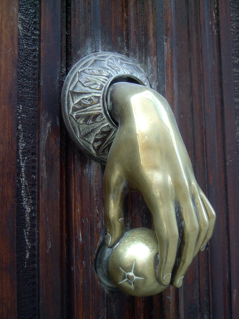 a ss door handle holding onto a wooden door