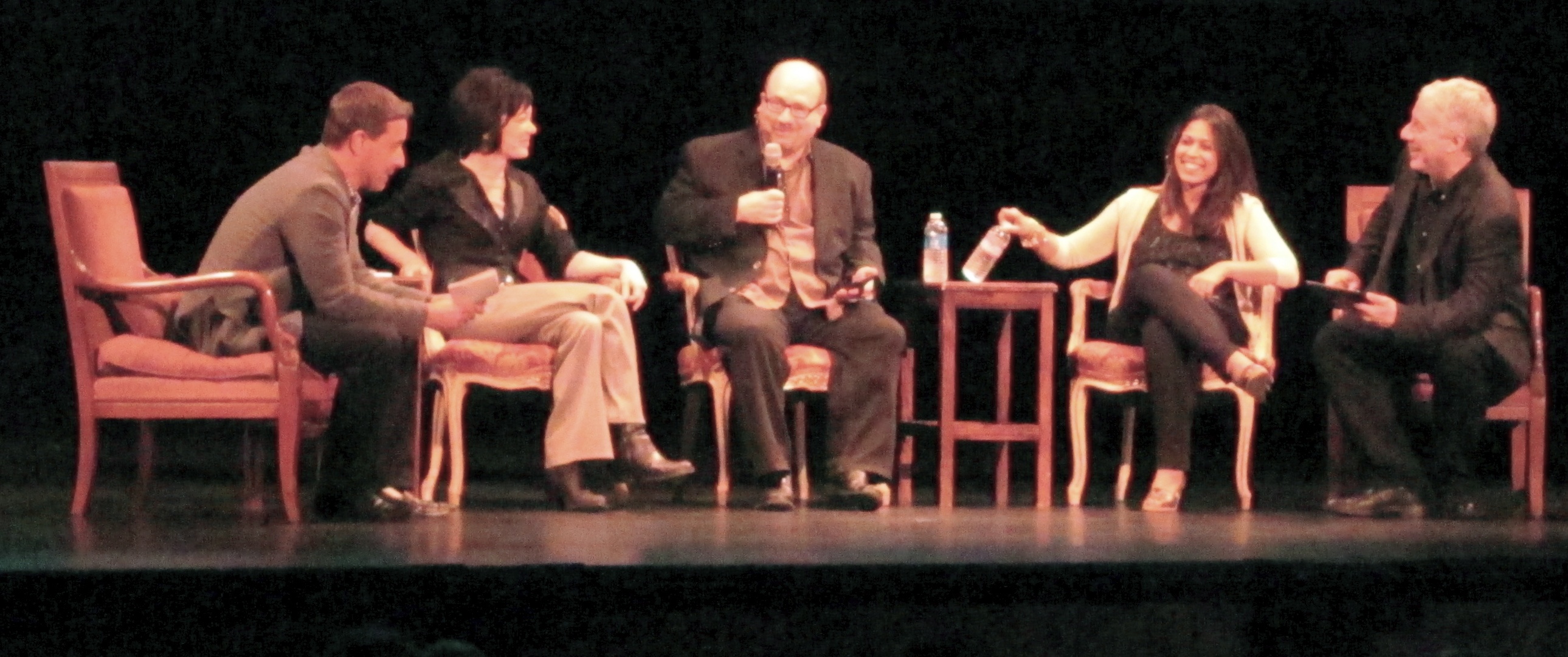 four people sitting in chairs having a discussion