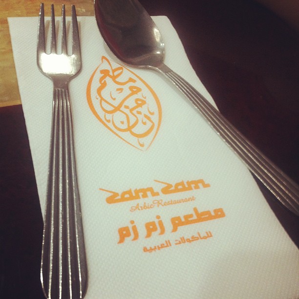 the fork has been placed next to a napkin with an orange islamic logo